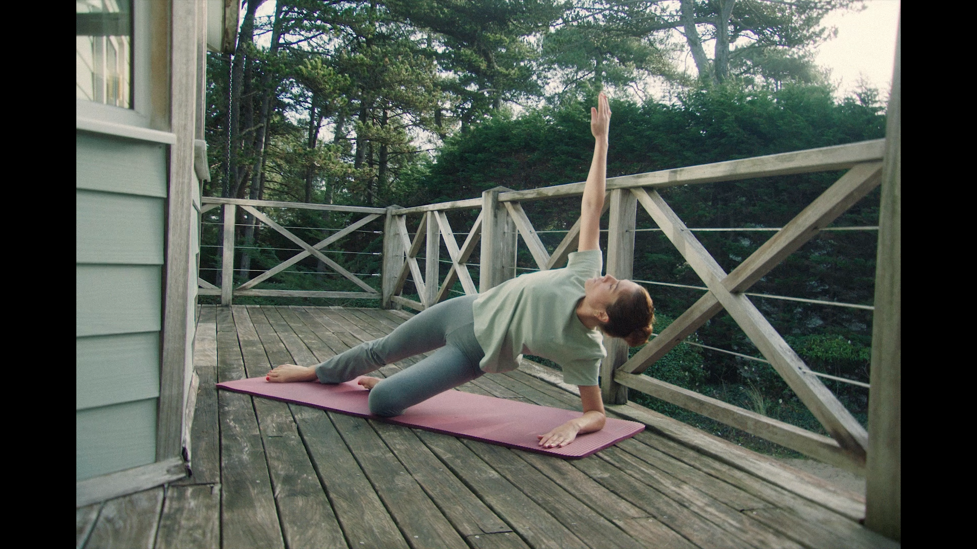 image issue d une campagne digitale montrant une fille pratiquant du pilates sur sa terrasse dans la foret