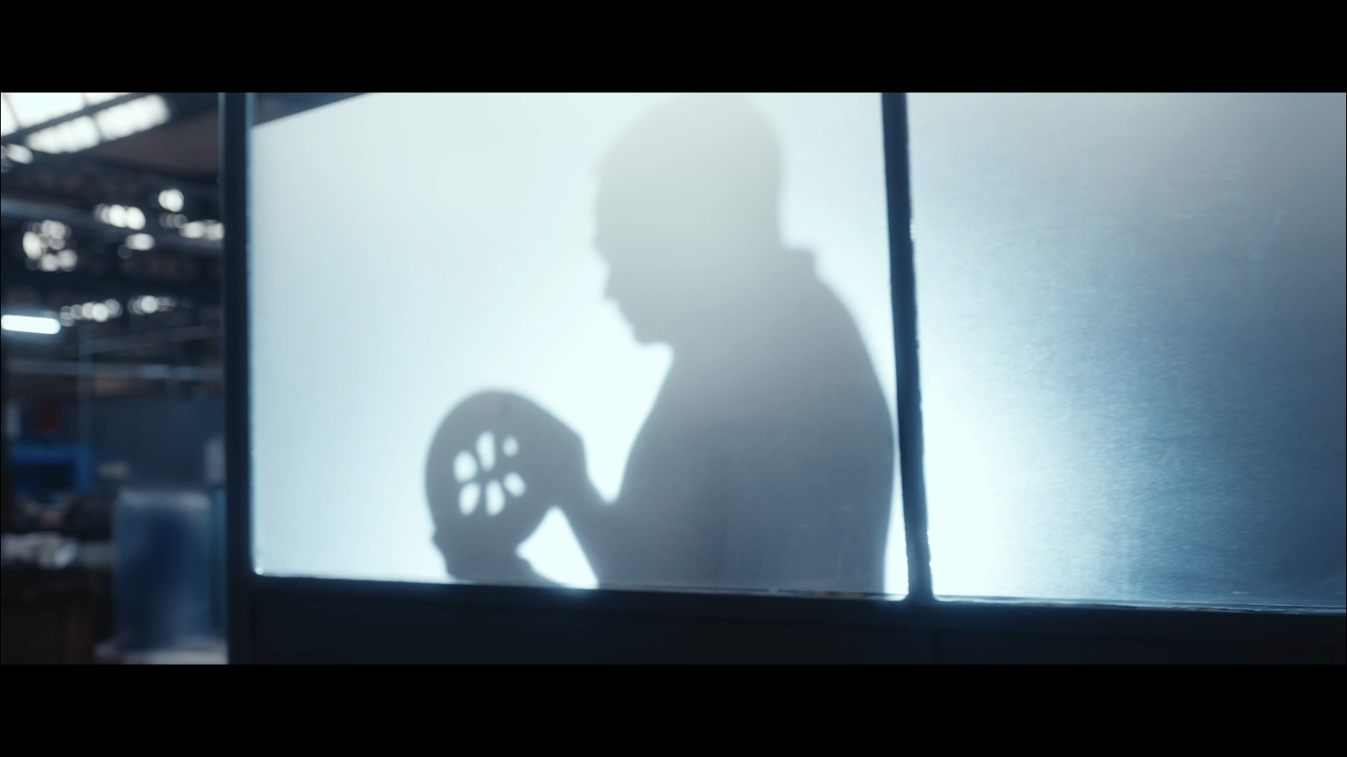 image issue d une video corporate montrant la silhouette d un homme derrière une cloison transparente
