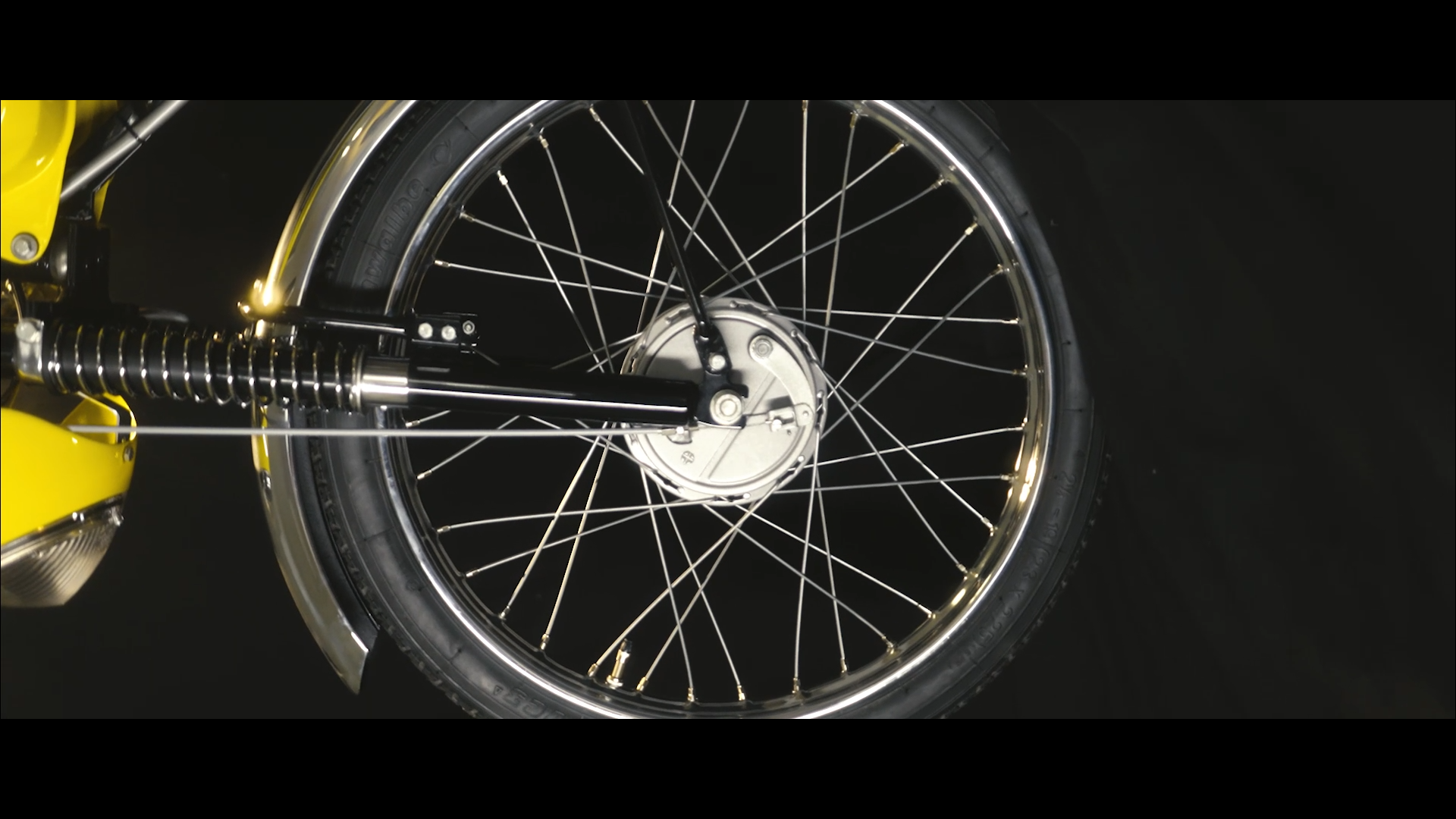 image issue d une video corporate montrant une roue de moto sur fond noir