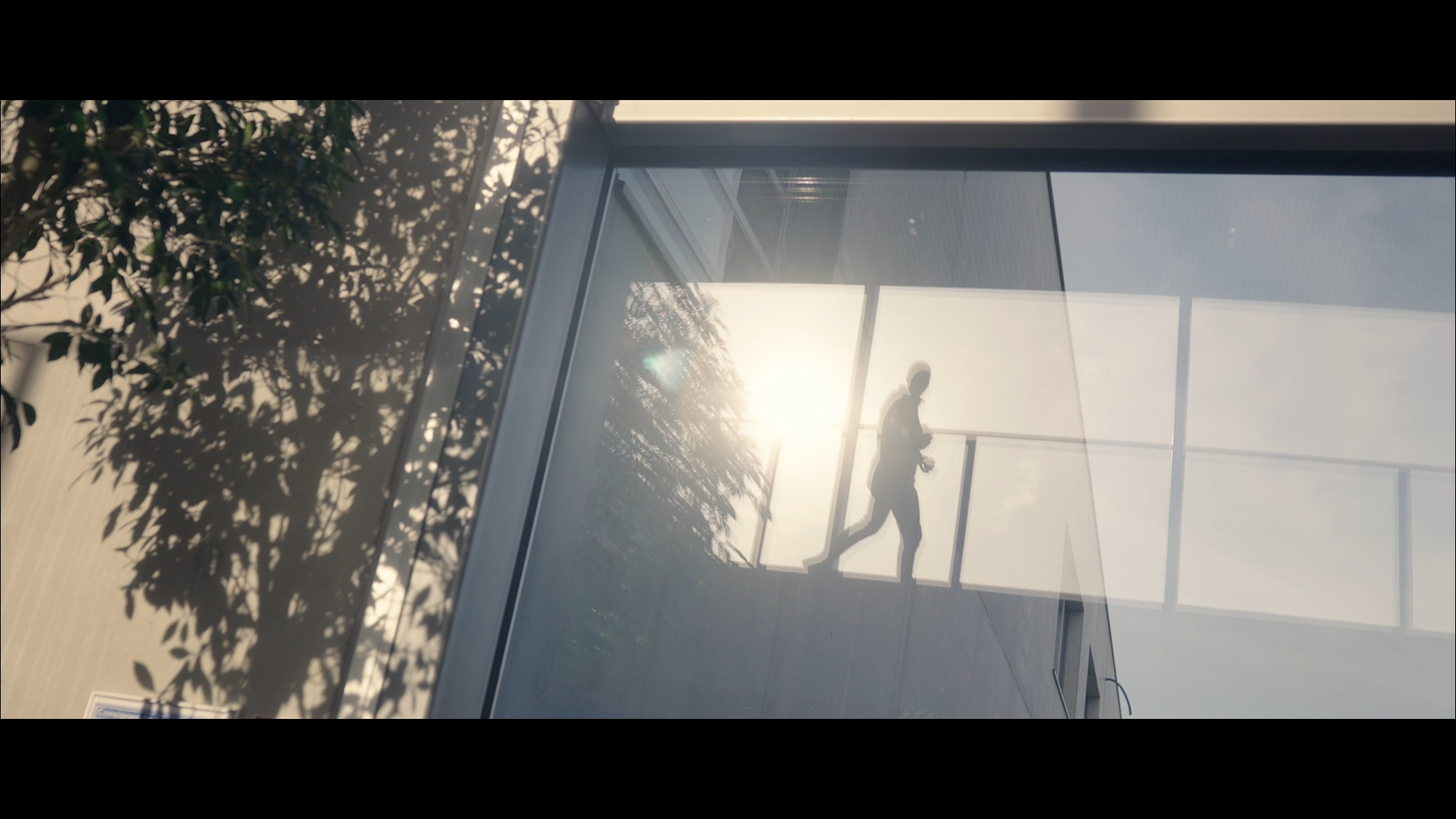 image issue d une video corporate montrant une silhouette dans les reflets d une facade vitree