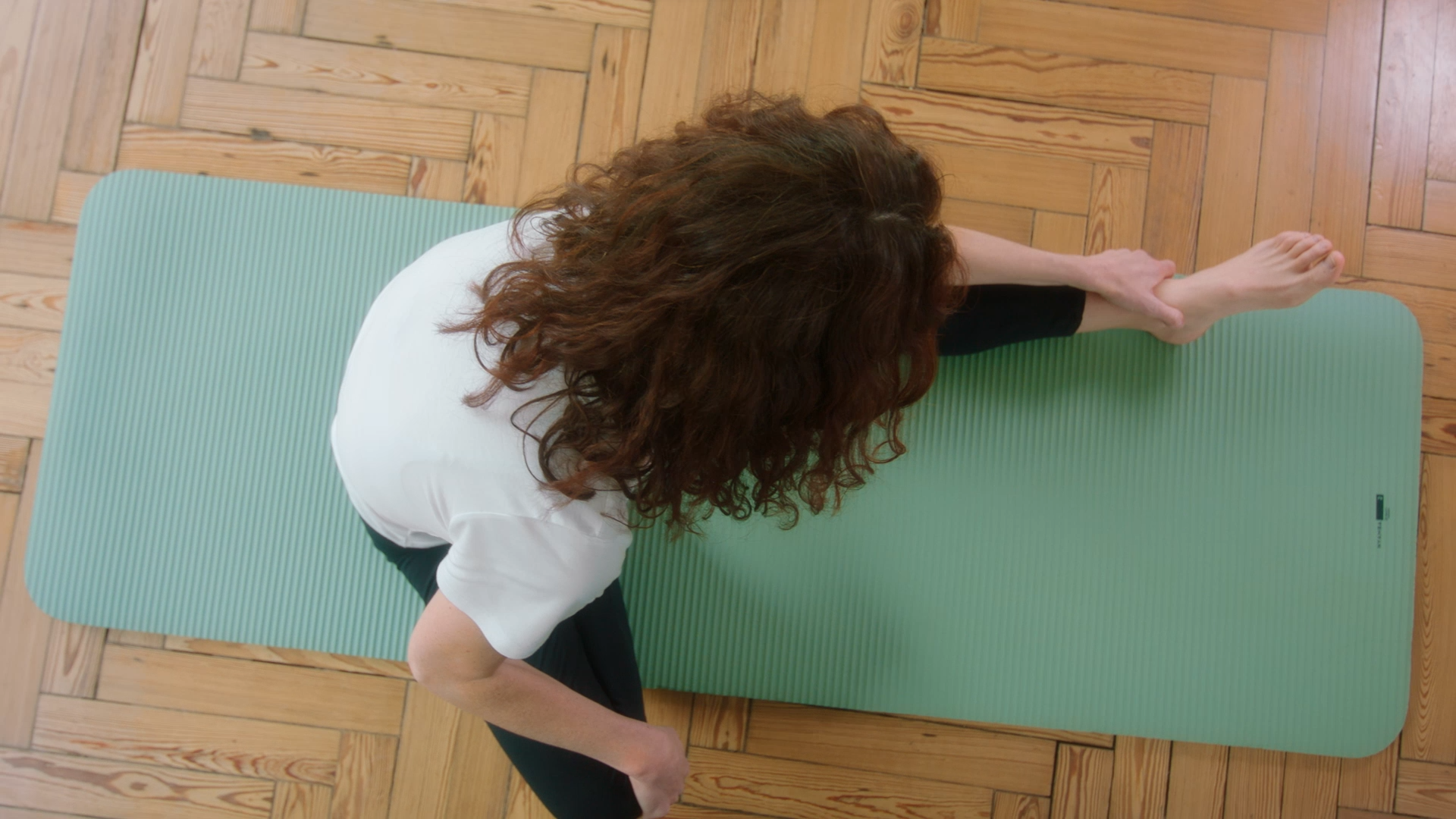 image issue d une video produit présentant une femme sur un tapis en train de faire du pilates