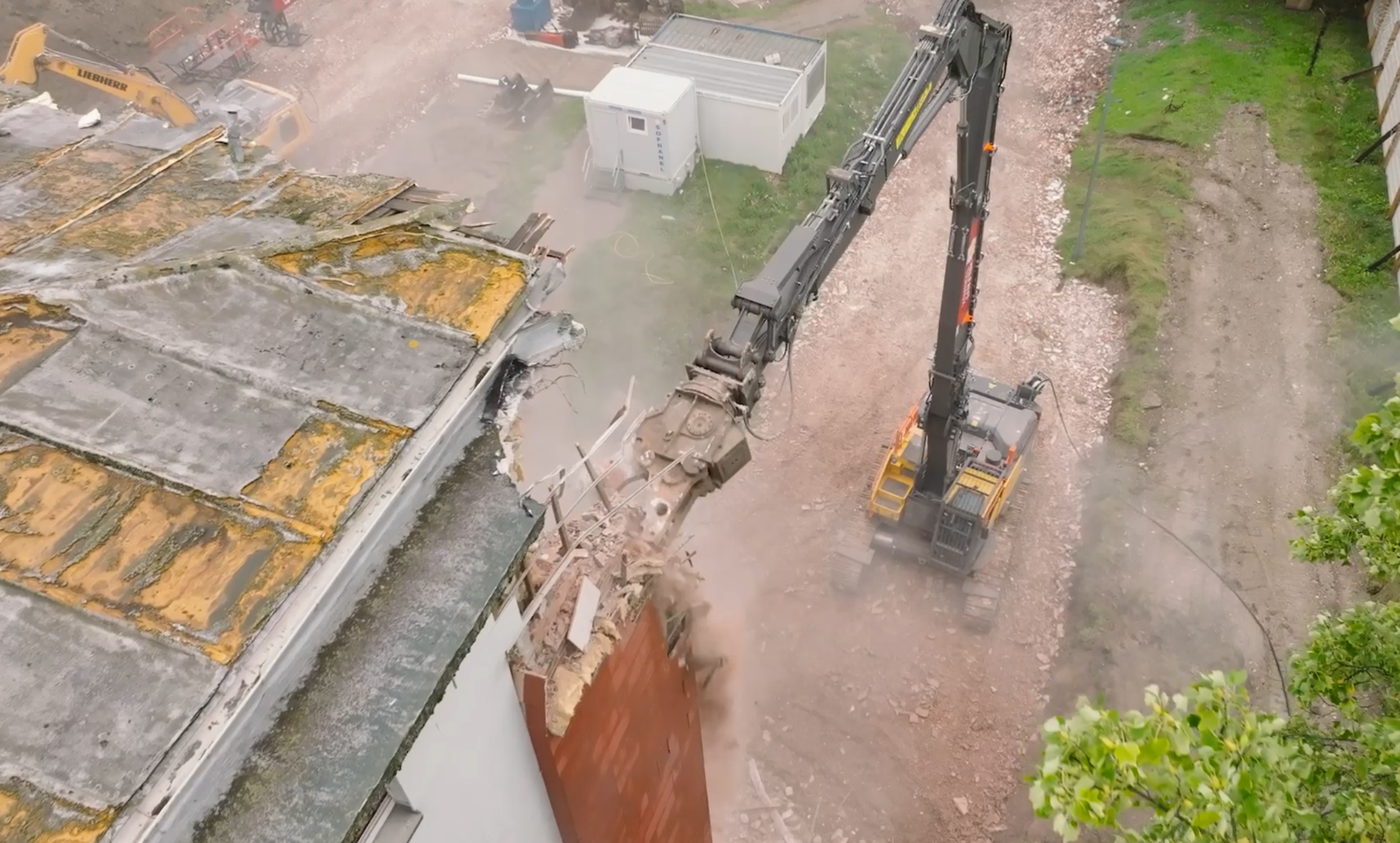 Image issue d'un reportage vidéo vue du haut d'un immeuble filmé au drone lors de sa destruction par une machine de chantier